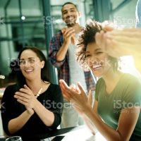 Shot of a team of creative businesspeople applauding an achievement  while working late in the boardroom